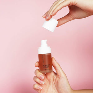 Hand holding BEAUTYPRO Vitamin C 10% serum pump bottle — daily brightening serum for glowing even skin